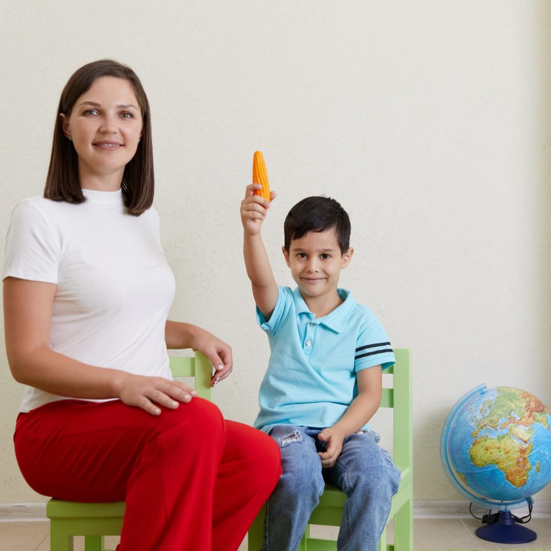 Teacher and preschool child are playing in playroom